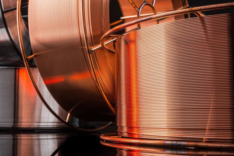Close-up of copper wire coils with reflected light and metallic surface details.